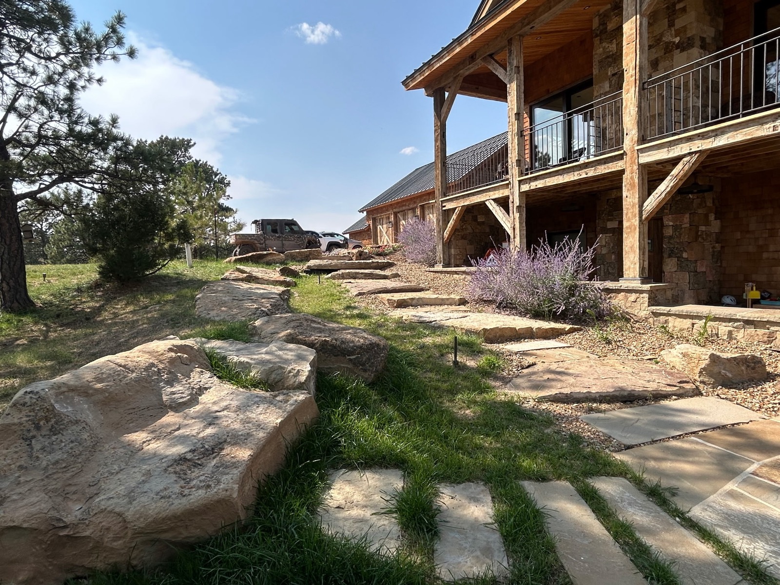 Quarter Circle 7 Ranch — natural stone steps and native grass alongside the lodge