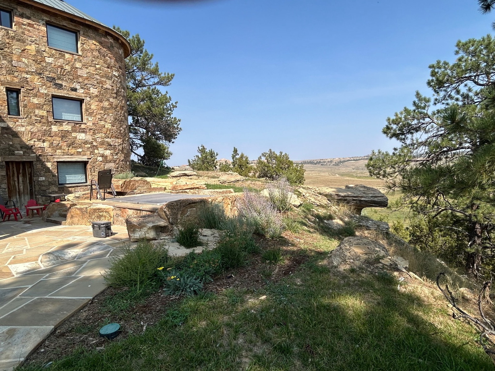 Quarter Circle 7 Ranch — stone patio and boulder landscape with prairie views